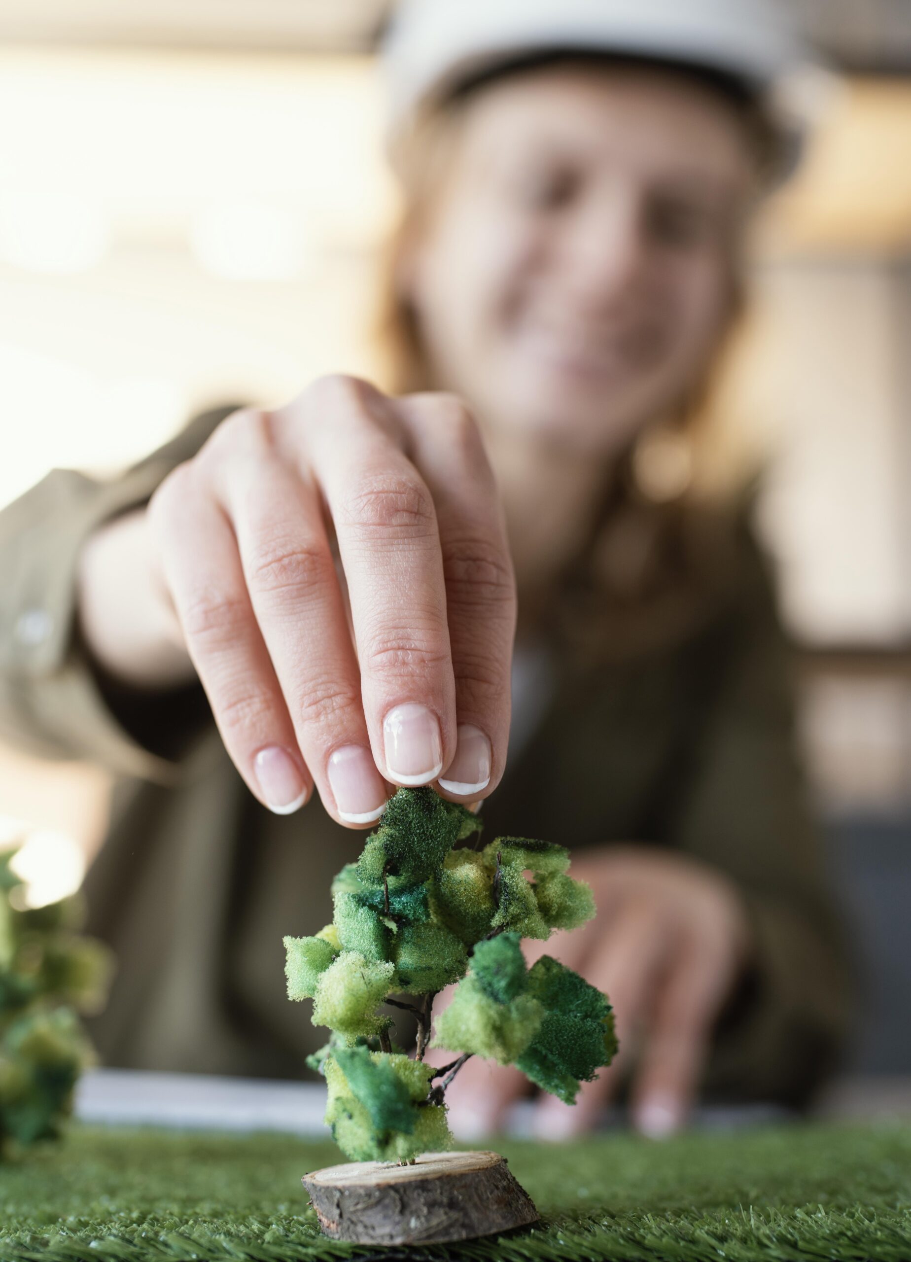Pessoa posicionando uma miniatura de árvore em um projeto ambiental, simbolizando práticas sustentáveis da Gallo Pneus.