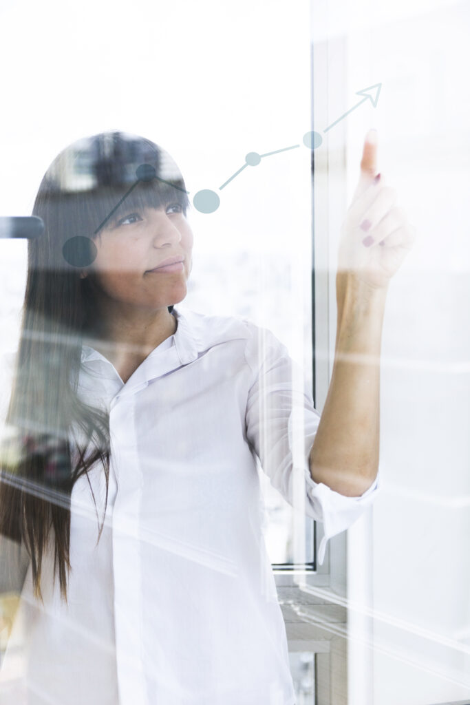 Profissional apontando para um gráfico de crescimento em vidro, simbolizando desempenho e evolução sustentável da Gallo Pneus.